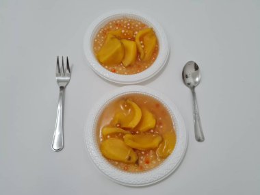 Olgun meyveler ve küçük tatlı toplarla dolu tatlı komposto.