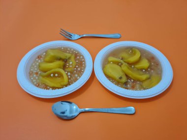 Olgun meyveler ve küçük tatlı toplarla dolu tatlı komposto.