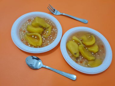 Olgun meyveler ve küçük tatlı toplarla dolu tatlı komposto.