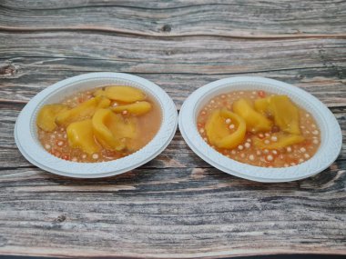 Olgun meyveler ve küçük tatlı toplarla dolu tatlı komposto.