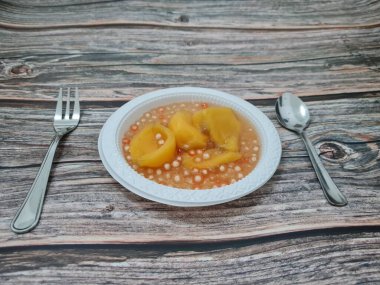 Olgun meyveler ve küçük tatlı toplarla dolu tatlı komposto.