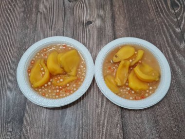 Olgun meyveler ve küçük tatlı toplarla dolu tatlı komposto.