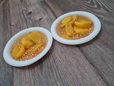 Olgun meyveler ve küçük tatlı toplarla dolu tatlı komposto.