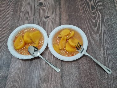 Olgun meyveler ve küçük tatlı toplarla dolu tatlı komposto.