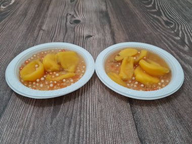 Olgun meyveler ve küçük tatlı toplarla dolu tatlı komposto.