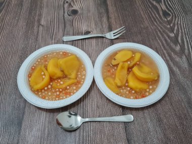 Olgun meyveler ve küçük tatlı toplarla dolu tatlı komposto.