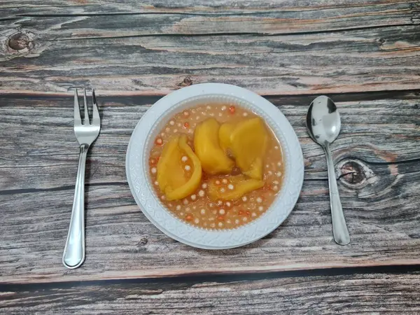 Olgun meyveler ve küçük tatlı toplarla dolu tatlı komposto.