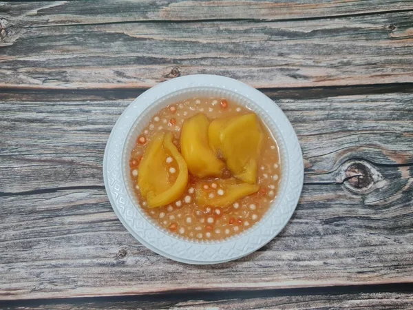 Olgun meyveler ve küçük tatlı toplarla dolu tatlı komposto.