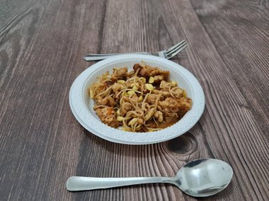 İçinde tempeh parçaları, tofu parçaları, lezzetli baharatlı fasulye filizleri olan bir çorba tabağı.