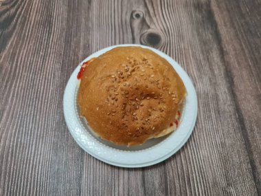 Dilimlenmiş etle dolu bir hamburger, lezzetli baharatlı taze sebzeler.