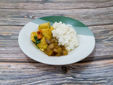 Pirinç ve yanında dilimlenmiş soya peyniri ve leziz baharatlı sığır eti.