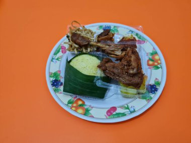 Yanında kızarmış tavuk, baharatlı yumurta ve kızarmış erişte ile birlikte sarı pirinç.