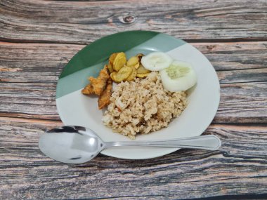 Kızarmış balık ve salatalık dilimli bir tabakta leziz pilav.