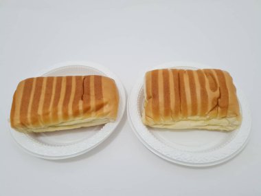 Kahverengi çizgili ekmek ve beyaz bir kap dolusu çikolata.