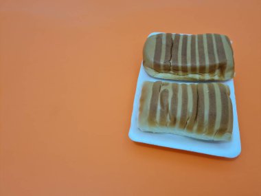 Kahverengi çizgili ekmek ve beyaz bir kap dolusu çikolata.