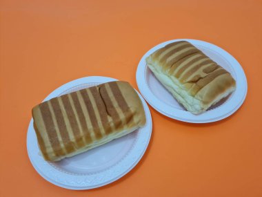 Kahverengi çizgili ekmek ve beyaz bir kap dolusu çikolata.