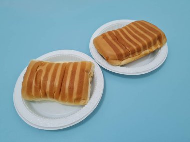 Kahverengi çizgili ekmek ve beyaz bir kap dolusu çikolata.