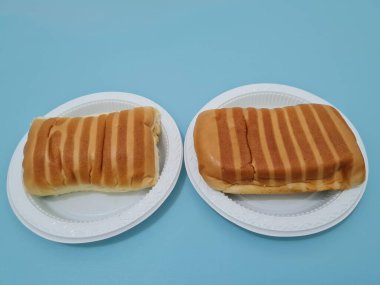 Kahverengi çizgili ekmek ve beyaz bir kap dolusu çikolata.