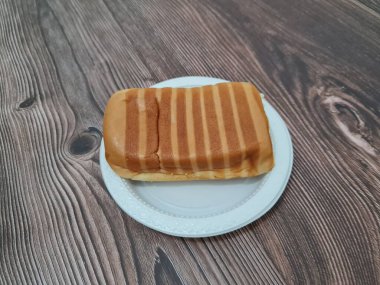 Kahverengi çizgili ekmek ve beyaz bir kap dolusu çikolata.