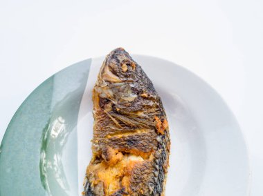 Tabakta kızartılmış tuzlu tilapia yan yemek olarak kullanılabilir veya doğrudan yenebilir.