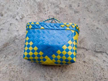 Mavi ve sarı plastik bir alışveriş çantası.