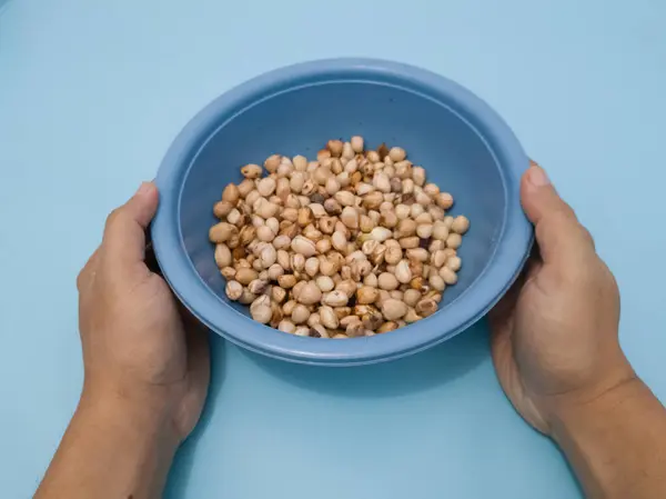 Peanuts that have been peeled from the skin in a blue container