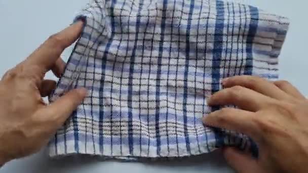 Mouvement Des Mains Jeune Homme Pliant Une Serviette Tissu Carreaux — Video
