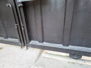 Arka plan için beton zemin ve beyaz duvarlı siyah metal çitler..