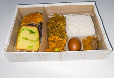 Kutudaki tipik Endonezya yemekleri arasında dilimlenmiş et, kızarmış erişte, pasta, sünger keki, kusmuk ve diğer şeyler vardır..