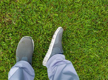 Yeşil çimenlerin üzerindeki spor ayakkabıların selfie 'si, fotokopi alanı olan üst manzara