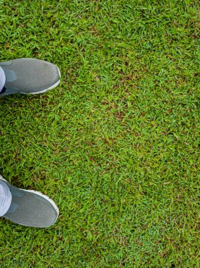 Yeşil çimenlerin üzerindeki spor ayakkabıların selfie 'si, fotokopi alanı olan üst manzara