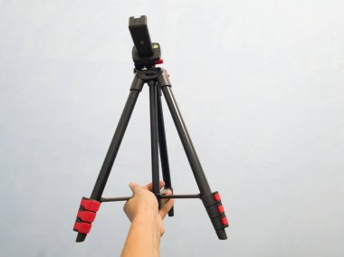 Beyaz arka planda kamera tripodu. Kameraya yaklaş..