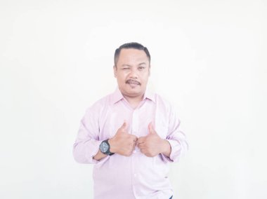 Kahverengi tenli Asyalı bir adam. Pembe gömlekli, beyaz arka planlı.