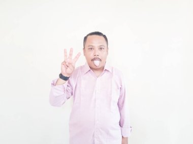 Kahverengi tenli Asyalı bir adam. Pembe gömlekli, beyaz arka planlı.