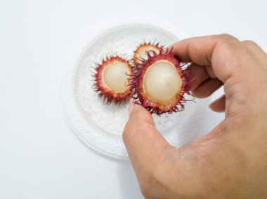 Beyaz arka planda beyaz bir plaka üzerinde Rambutan.