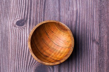 Tahta bir masada kahverengi ahşaptan yapılmış bir kase.