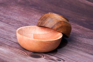 Tahta bir masada kahverengi ahşaptan yapılmış bir kase.