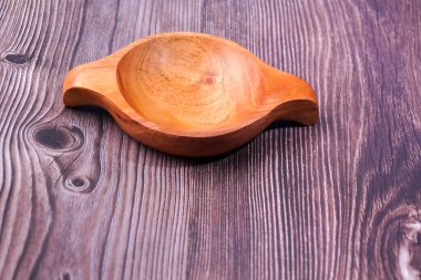 Tahta bir masada kahverengi ahşaptan yapılmış bir kase.