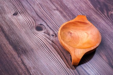 Tahta bir masada kahverengi ahşaptan yapılmış bir kase.