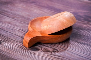 Tahta bir masada kahverengi ahşaptan yapılmış bir kase.