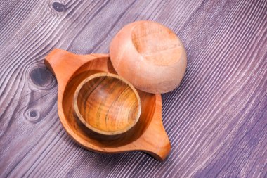 Tahta bir masada kahverengi ahşaptan yapılmış bir kase.