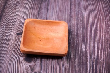 Tahta bir masada kahverengi ahşaptan yapılmış bir kase.