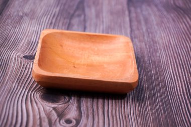 Tahta bir masada kahverengi ahşaptan yapılmış bir kase.