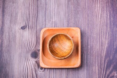 Tahta bir masada kahverengi ahşaptan yapılmış bir kase.