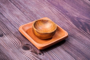 Tahta bir masada kahverengi ahşaptan yapılmış bir kase.