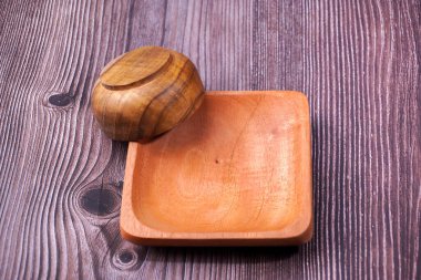 Tahta bir masada kahverengi ahşaptan yapılmış bir kase.