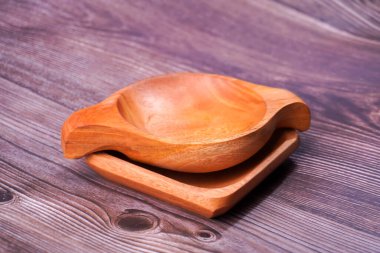 Tahta bir masada kahverengi ahşaptan yapılmış bir kase.