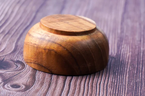 Tahta bir masada kahverengi ahşaptan yapılmış bir kase.