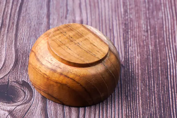 Tahta bir masada kahverengi ahşaptan yapılmış bir kase.