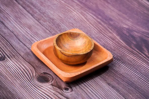 Tahta bir masada kahverengi ahşaptan yapılmış bir kase.